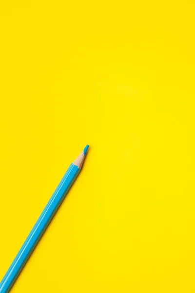 Diagonal blue sharp wooden pencil on a bright yellow background, isolated, copy space, mock up — Stock Photo, Image