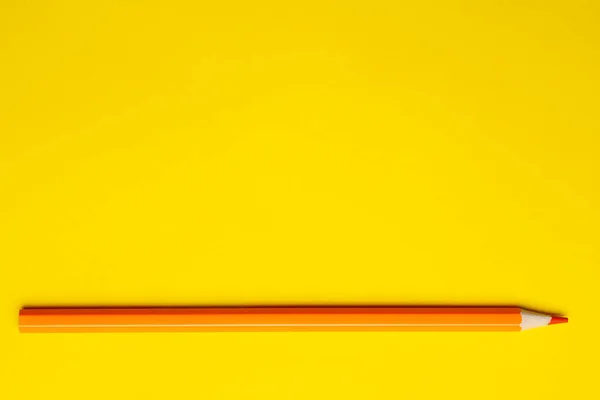 Lápiz de madera afilado naranja horizontal sobre un fondo amarillo brillante, aislado, espacio de copia, se burlan de — Foto de Stock