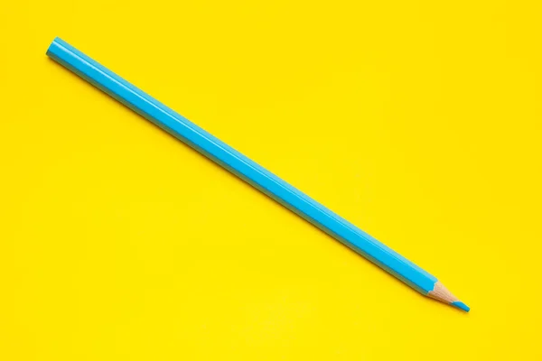 Diagonal blue sharp wooden pencil on a bright yellow background, isolated, copy space, mock up — Stock Photo, Image