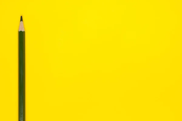 밝은 노란색 배경에 있는, 선명 한 검은색의 날카로운 나무 연필, 따로 떨어져 있고, 복사 공간에 있으며, — 스톡 사진
