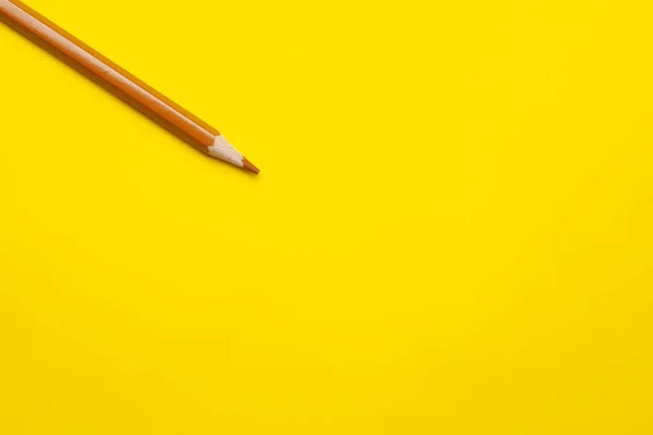 Lápiz de madera afilado marrón claro diagonal sobre un fondo amarillo brillante, aislado, espacio de copia, se burlan de — Foto de Stock