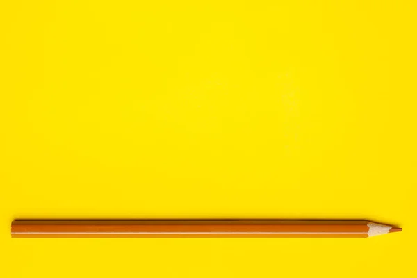 Vízszintes fény barna éles fa ceruza egy fényes sárga háttér, elszigetelt, másolás tér, gúnyolódni — Stock Fotó