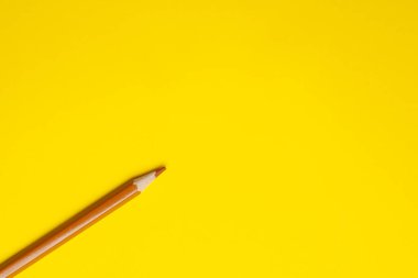 Parlak sarı bir zemin üzerinde köşegen açık kahverengi, tahta kalem, izole edilmiş, kopyalama alanı, taklit