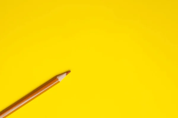 Lápiz de madera afilado marrón claro diagonal sobre un fondo amarillo brillante, aislado, espacio de copia, se burlan de —  Fotos de Stock