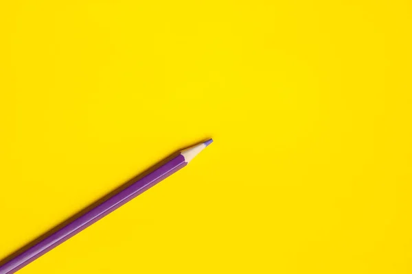 Diagonal purple sharp wooden pencil on a bright yellow background, isolated, copy space, mock up — Stock Photo, Image