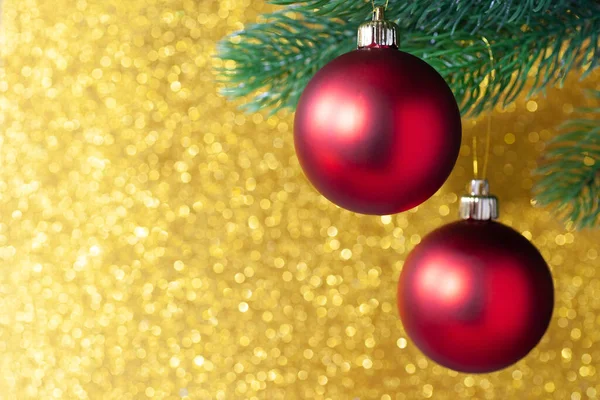 Dwie czerwone błyszczące kulki na gałęzi drzewa noworocznego na żółtym rozmytym tle, makieta — Zdjęcie stockowe