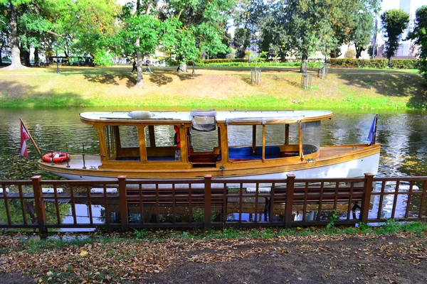 RIGA, LATVIA .Cruzeiro navio de barco turístico flutuando no rio canal no parque Bastion Hill Riga. 28 de setembro de 2018 — Fotografia de Stock