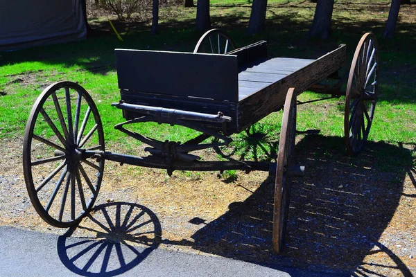 Old wooden cart on the green grass on side of road — Stock Photo, Image