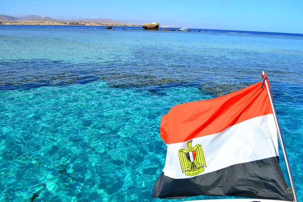 Egyptian flag on the background of the Red Sea. Flag of Egypt on background of sea and Tiran island,Sharm El Sheikh, Egypt, January 6, 2019