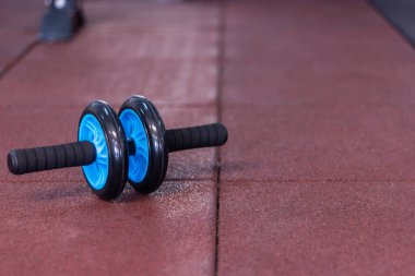 Kırmızı kauçuk üzerinde mavi ve siyah spor salonu tekerleği