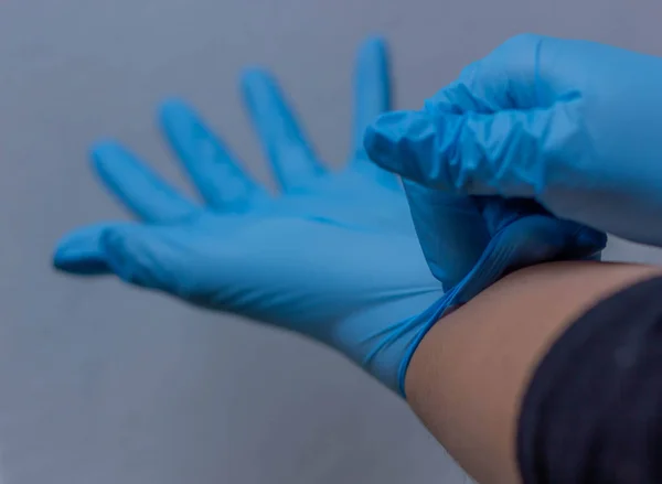 blue vinyl gloves on white background stay home