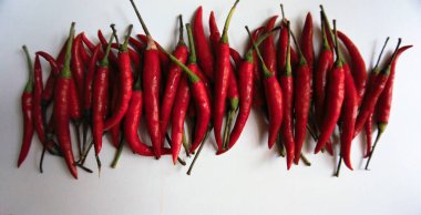 Kırmızı biberlerin beyaz arka planda çok baharatlı bir tadı vardır..