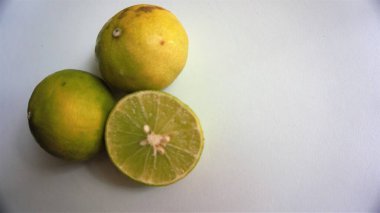 İki limon Asya meyvesi yeşil ve sarı kürelerdir. ve kireç kes.