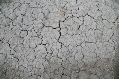 Kurumuş toprağın dokusu kil ve kumla yakın plan. Kuru çatlamış toprak arka planı, kil çöl dokusu.