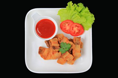 Kızarmış domuz eti, beyaz tabakta balık sosu, marul ve domatesle garnitür 