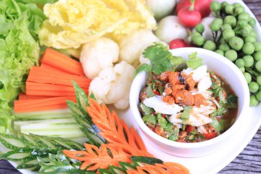 Baharatlı Yengeç Roe Relish Paste ve eski ahşap arka planda taze sebze karışımı.