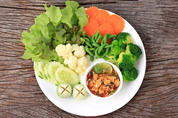 Baharatlı Yengeç Roe Relish Paste ve eski ahşap arka planda taze sebze karışımı. 