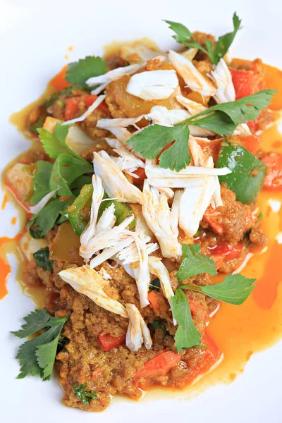 Köri tozu ile karıştırılmış yengeç eti, üstü beyaz tabakta haşlanmış yengeç etiyle süslenir. 