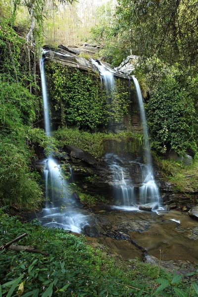 Manfa Şelale Mağarası, Mae Sapok Şelalesi 'nin arkasına giden küçük bir geçit. Şelale perdesi bir dereye akıyor, Ban Mae Win, Chiang Mai Eyaleti, Tayland