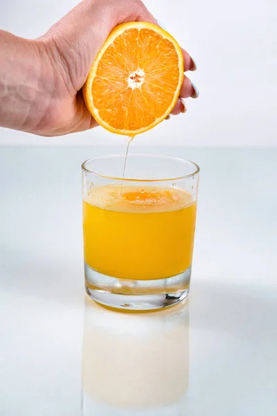 Serrant Main Orange Dans Verre Avec Une Boisson Couleur Orange — Photo
