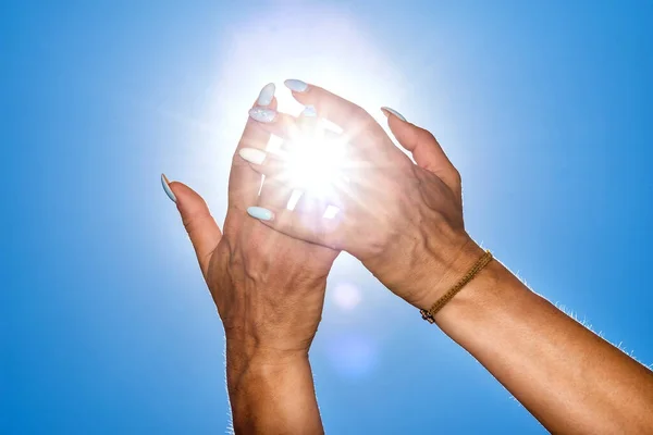 Hands with sun light going through the middle of the fingers.