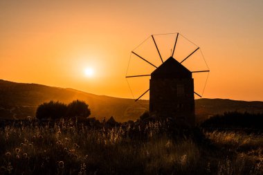 Gün batımında eski bir yel değirmeni silueti. Girit adası.