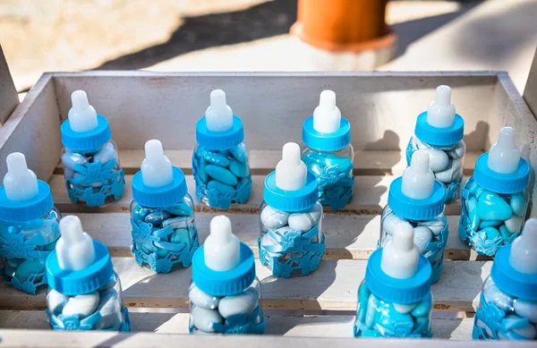 Favor in the form of child bottles filled with candies for the guest attending the boy baptism