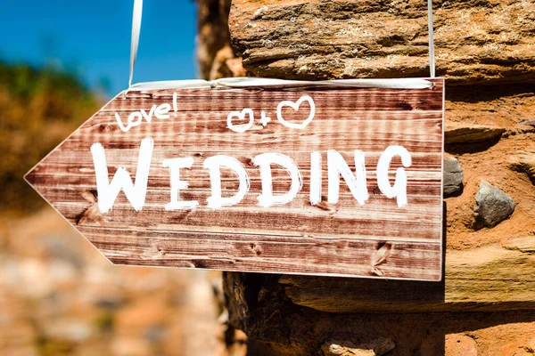 Wooden sign pointing to the place of wedding ceremony and party.