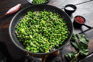 Kızartma tavasında bezelyesiz bezelye glüten ve nane arpacığı biberli bezelye ve eski bar ahşap yüzeyi üzerinde tuz kenarı manzaralı bezelye tarifi. Yeni geniş melek manzarasını kapat..
