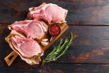 Barbekü domuz eti porsiyonu, eski koyu ahşap masa üzerine kurulmuş, şifalı otlar ve metin için üst görünüm alanı.