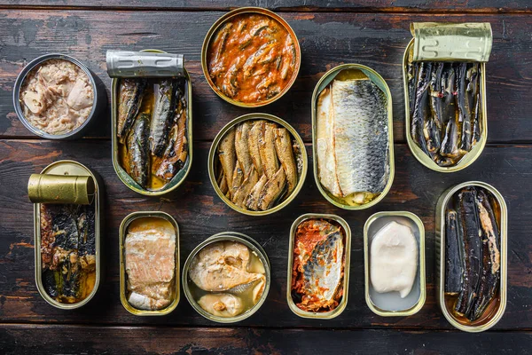 Saury, uskumru, sprat, sardalya, sardalya, kalamar, kalamar, ton balığı ve eski bar ahşap masa. .