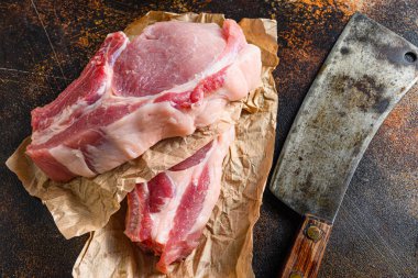 Kağıtlara sarılmış çiğ domuz pirzolası ve içinde kasap baltası var..