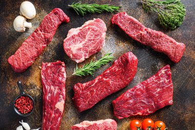 Alternatif çiğ biftek kanat bifteği, pala bifteği ya da etek kesimi, üst bıçak ya da düz demir et ve üçlü uç, Denver 'la üçlü rosto, eski rustik metal yüzey üzerine yan görüş. .
