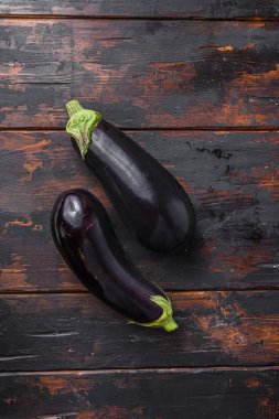Mutfaktaki eski, siyah ahşap masada taze, çiğ, mor patlıcan. Üst görünüm