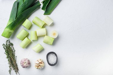 Çiğ doğranmış pırasa mangalda pişirilmemiş otlar, desenli beyaz arka plan görünümünde metin için boşluk