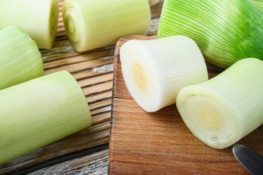 Choppong tahtasında yeşil doğranmış pırasa sultan beyaz ahşap masa manzarası seçici odak üzerinde