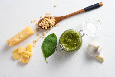 Cam kavanozdaki klasik Basil pesto sosu. Taze fesleğen yaprağı, rendelenmiş parmesan peyniri, çam fıstığı, sarımsak, beyaz masa betonu....