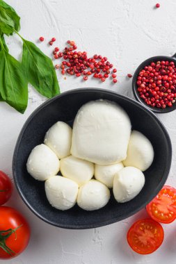 Siyah kasede Mozzarella peyniri, fesleğen domates kiraz balzamik siyah kayrak taşı fotokopi alanı. Beyaz arkaplanda Caprese salatası için gerekenler dikey olarak kapat.
