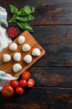 Taze kiraz domatesleri, fesleğen yaprağı, mozzarella peyniri eski ahşap masa arkasında dikey metin için boşluk.