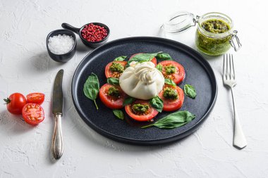 Burrata Buffalo peyniri taze domates ve fesleğen yapraklı sos ile servis edilir. .