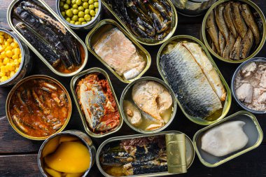 Konserve konserveleri, konserve kutularındaki yiyecekleri korur. Taze organik katkı maddeleri Saury, uskumru, sprat, sardalya, sardalya, sardalya, kalamar, ton balığı anananası, mısır, bezelye, mango, fasulye, eski ahşap desenli üst görünüm.