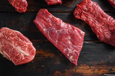Biyo kanat bavette ya da biftek biftek biftek üç uçlu biftek ve üst bıçaklı istiridye kesikleri eski ahşap masa üst görüşünde kasaplık diğer kesiklerin önünde yakın.