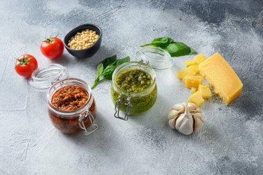 Ev yapımı vejetaryen pesto normal pesto ve kırmızı pesto ve pişirme malzemeleri parmesan peyniri, fesleğen yaprağı, çam fıstığı, zeytinyağı, sarımsak, tuz, biber sosu..