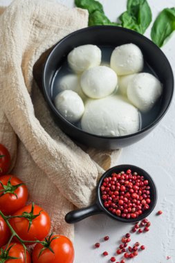 mozzarella bufalosu, taze fesleğen, kırmızı domates ve zeytinyağı. İtalyan mutfağı, sağlıklı öğle yemeği. İtalyan caprese salatası. bez ve beyaz arkaplan.