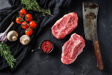 Çiğ üst bıçak organik et biçer kasap akıllı bıçak bbq veya ızgara üst görünüm için siyah taş arka plan üzerinde.