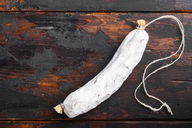 Koyu ahşap arka planda kurutulmuş salçalı İspanyol sosisi..