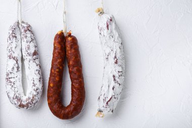 Chorizo ve fuet salamları beyaz desenli arka planda kopyalama alanı ile.