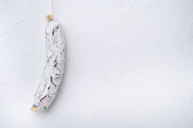 Beyaz arkaplanda salam sosisi ve metin için boşluk.