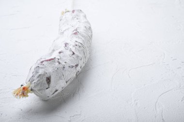 Beyaz arkaplanda salam sosisi ve metin için boşluk.