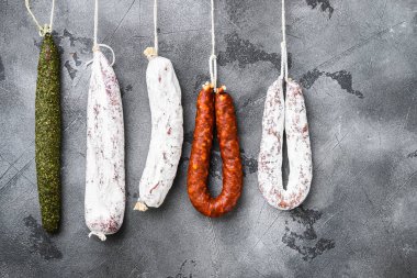 İspanyol kuru salamı, gri dokulu arka plandaki bir raftan..